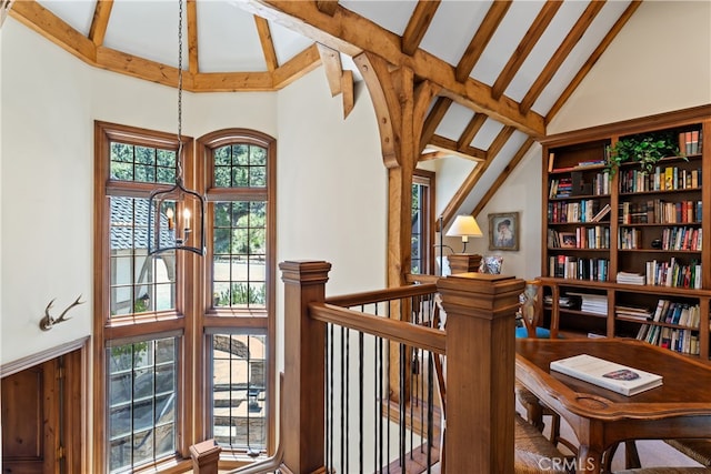 hallway featuring an inviting chandelier, beam ceiling, and high vaulted ceiling