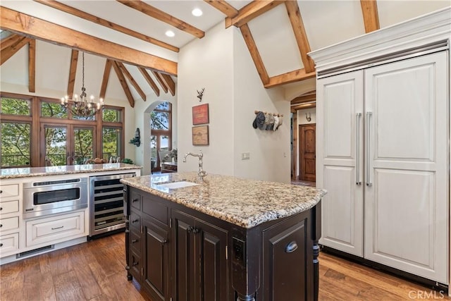 28964 Quail Run Ct, Lake Arrowhead, CA 92352 - kitchen featuring beverage cooler, a sink, a chandelier, light stone counters, and dark wood-type flooring