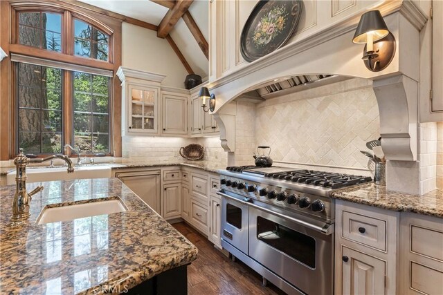 kitchen featuring decorative backsplash, vaulted ceiling with beams, custom range hood, dark wood-type flooring, and range with two ovens