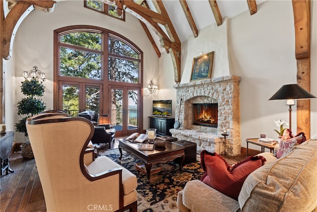 living room featuring a healthy amount of sunlight, high vaulted ceiling, dark wood-type flooring, and a fireplace