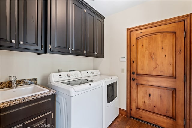 laundry area featuring dark wood-type flooring, cabinets, sink, and washing machine and clothes dryer