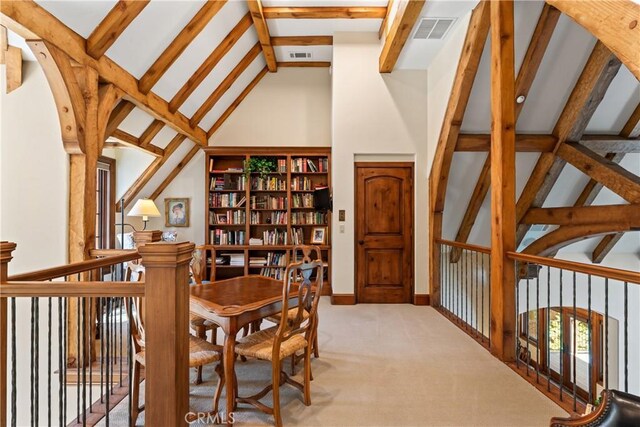 interior space with beamed ceiling, light colored carpet, and high vaulted ceiling