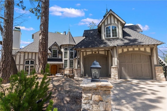 28964 Quail Run Ct, Lake Arrowhead, CA 92352 - tudor home featuring stucco siding, stone siding, an attached garage, and concrete driveway