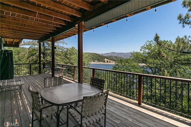 deck with a water and mountain view