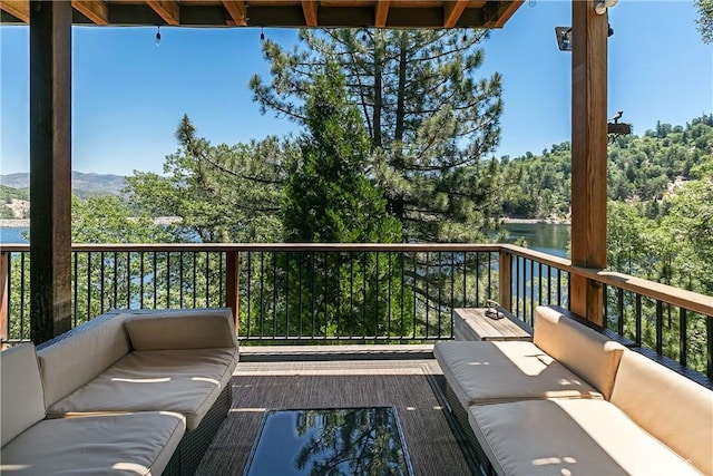 balcony with an outdoor living space and a water view