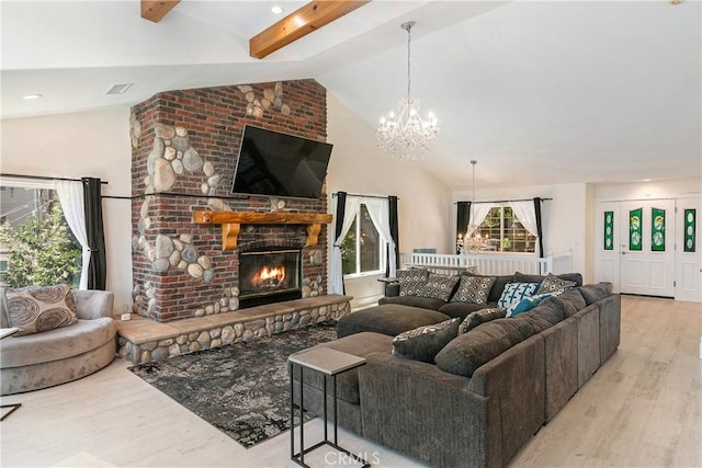 living room featuring vaulted ceiling with beams, light hardwood / wood-style floors, an inviting chandelier, and a brick fireplace