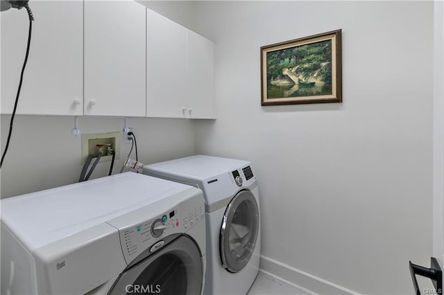 laundry room with washing machine and dryer and cabinets