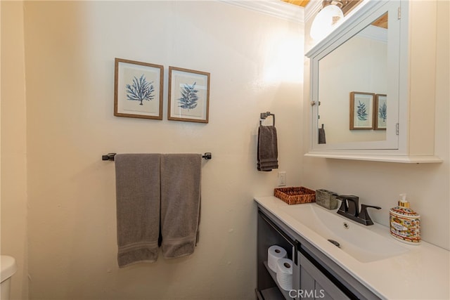 bathroom featuring vanity, toilet, and ornamental molding