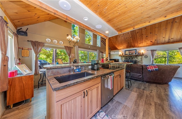 kitchen with a center island with sink, dark hardwood / wood-style flooring, stainless steel dishwasher, light brown cabinetry, and sink