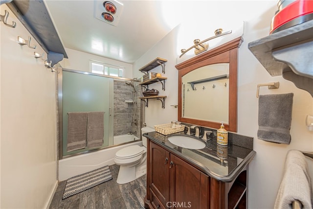 full bathroom with vanity, toilet, hardwood / wood-style flooring, and combined bath / shower with glass door