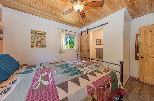 bedroom featuring wood ceiling, ceiling fan, a barn door, wood-type flooring, and crown molding