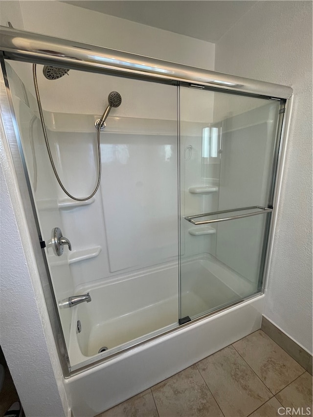 bathroom featuring tile patterned floors and bath / shower combo with glass door