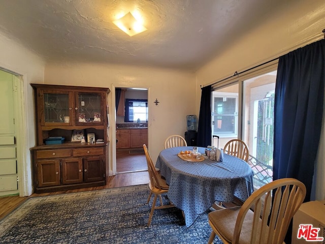 dining room with a textured ceiling, sink, and dark wood-type flooring