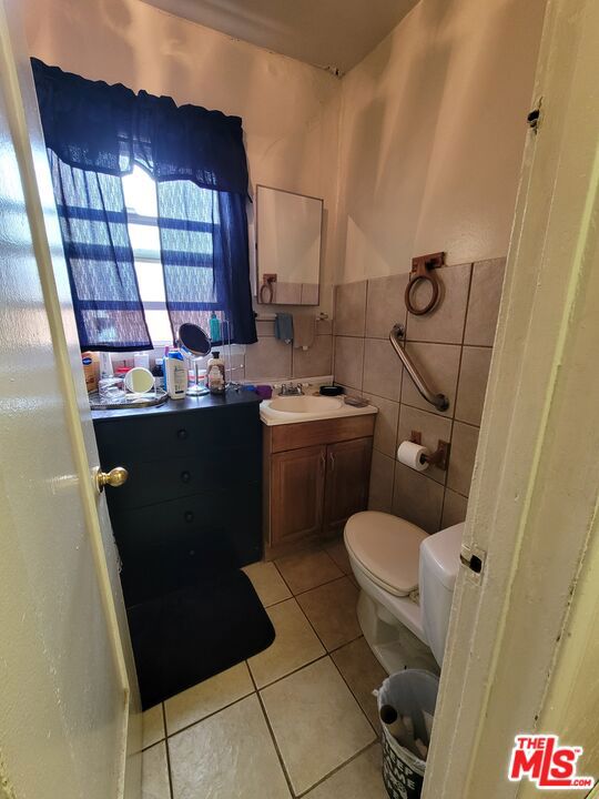 bathroom with vanity, tile walls, toilet, and tile patterned floors