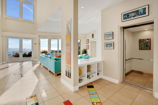 bathroom with a water view, tile patterned floors, and french doors