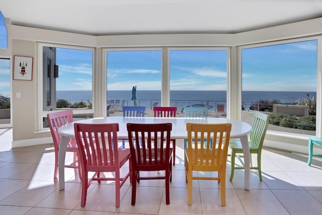 tiled dining room with a water view and a healthy amount of sunlight