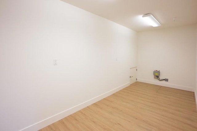 clothes washing area with light hardwood / wood-style flooring