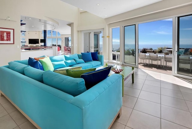 living room with a water view, a healthy amount of sunlight, and light tile patterned floors