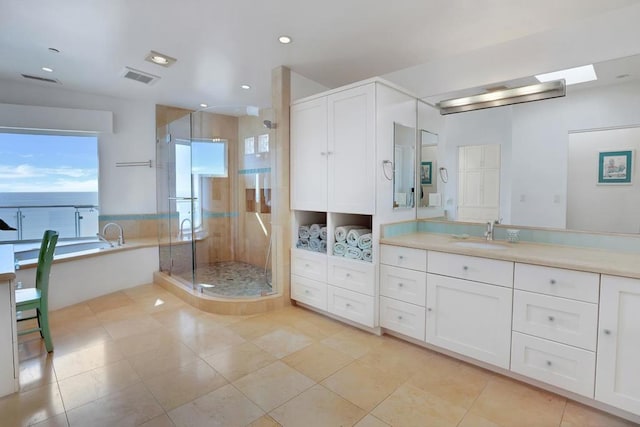 bathroom featuring tile patterned flooring, shower with separate bathtub, and vanity