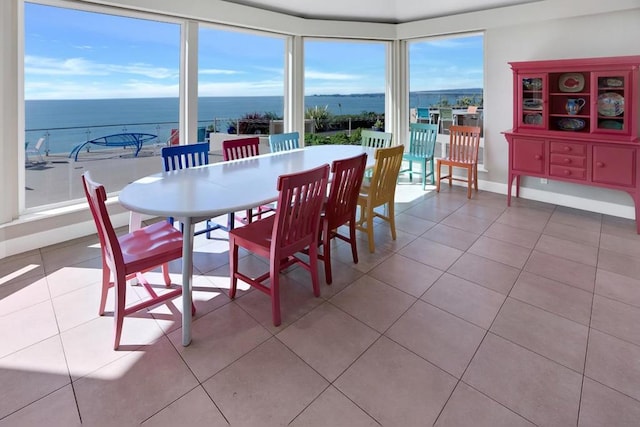 dining area with tile patterned flooring and a water view