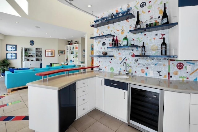 kitchen featuring wine cooler, kitchen peninsula, sink, and white cabinets