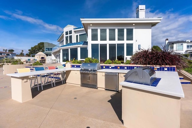 view of patio featuring an outdoor kitchen and a bar