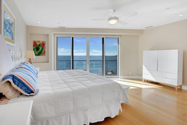 bedroom featuring a water view, ceiling fan, access to exterior, and light hardwood / wood-style floors