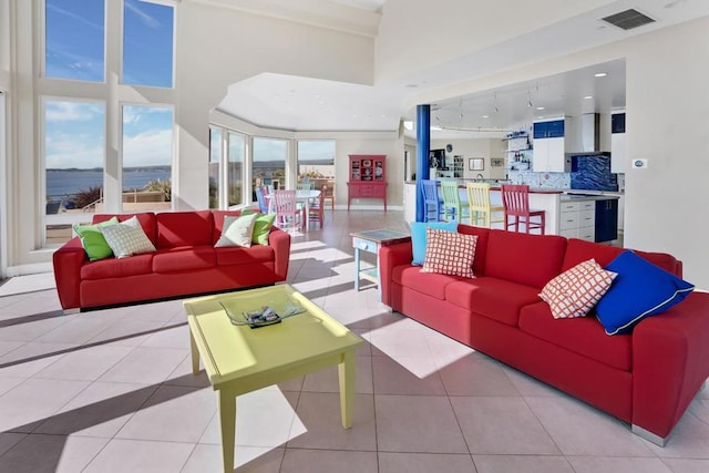 living room featuring light tile patterned flooring and a water view