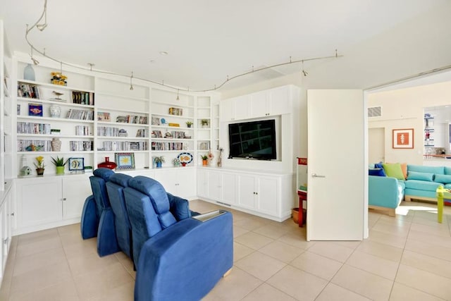 sitting room with built in shelves and light tile patterned floors