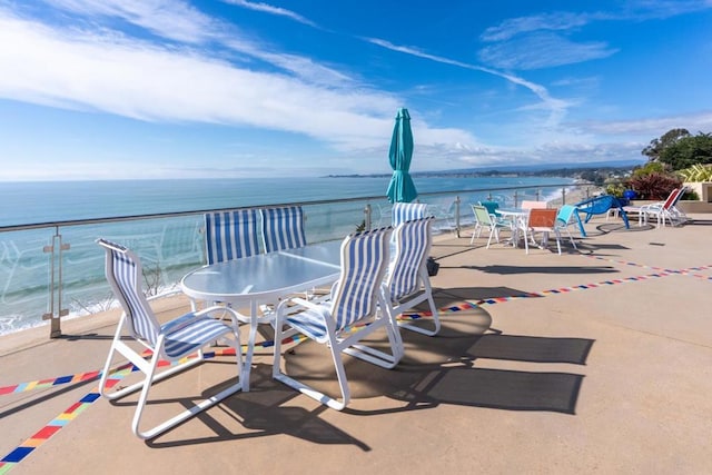 view of patio / terrace featuring a view of the beach, a balcony, and a water view