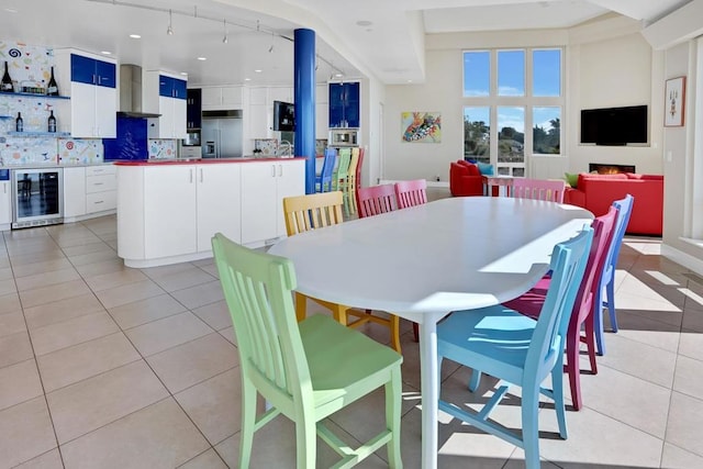 dining area featuring light tile patterned floors and beverage cooler