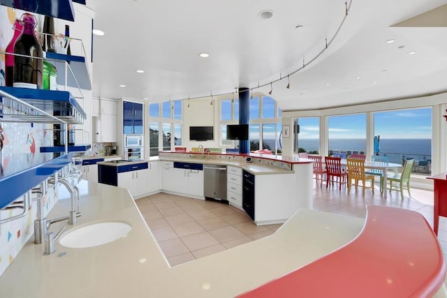 kitchen featuring white cabinetry, sink, light tile patterned floors, and stainless steel dishwasher