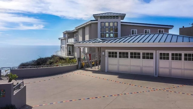 view of front of property featuring a garage and a water view