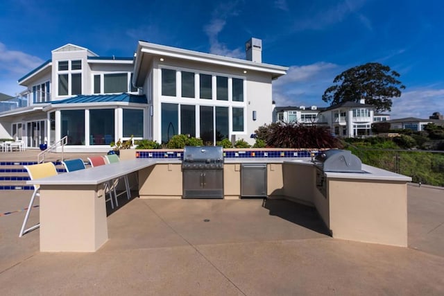 view of patio featuring grilling area, exterior kitchen, and an outdoor bar