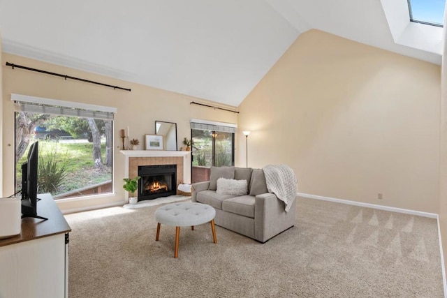 carpeted living room with a healthy amount of sunlight, a fireplace, and lofted ceiling with skylight