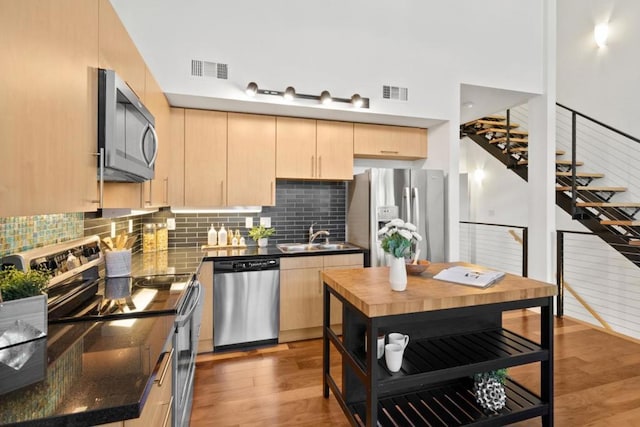 kitchen featuring light brown cabinetry, sink, appliances with stainless steel finishes, and light hardwood / wood-style flooring