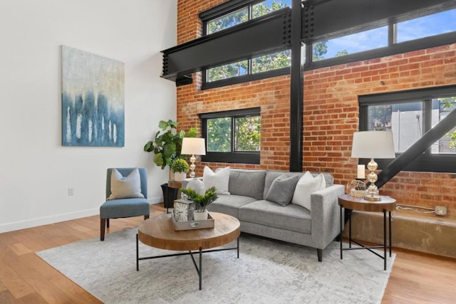 living room with wood-type flooring and brick wall