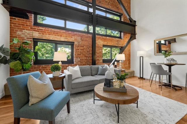 interior space featuring hardwood / wood-style floors, a high ceiling, and brick wall