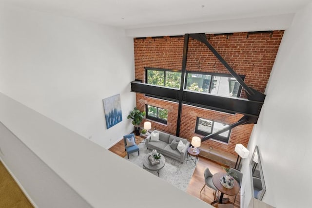 living room featuring brick wall and hardwood / wood-style flooring