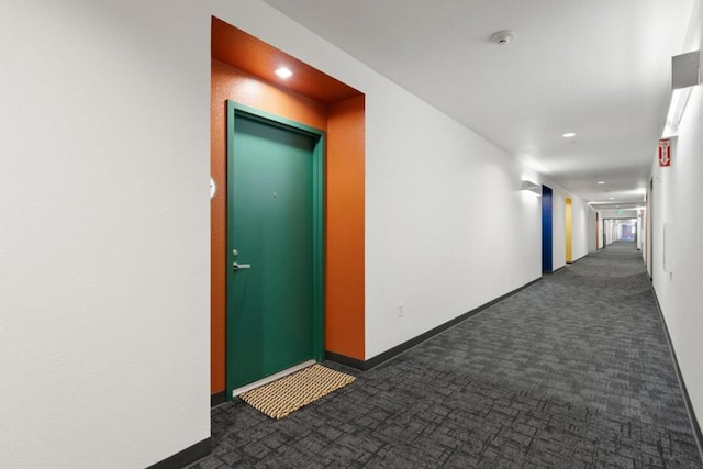 hall with dark colored carpet