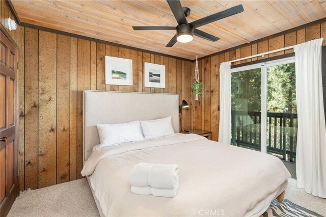 carpeted bedroom with wood walls, access to exterior, wooden ceiling, and ceiling fan