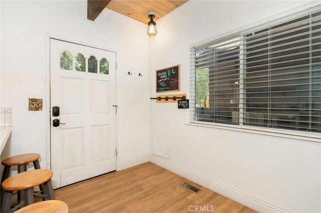 entrance foyer with light hardwood / wood-style floors, beamed ceiling, and wooden ceiling