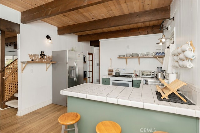 kitchen with tile counters, green cabinets, white gas stove, and sink