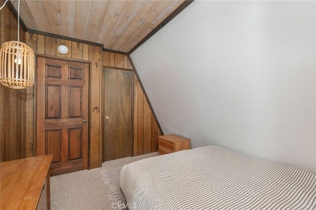 bedroom with wood ceiling, wood walls, light colored carpet, and vaulted ceiling