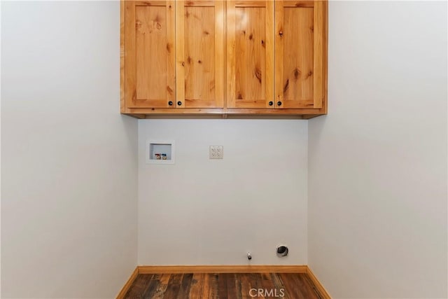 washroom featuring dark hardwood / wood-style flooring, hookup for a gas dryer, hookup for a washing machine, and cabinets