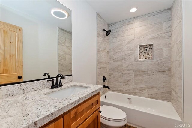 full bathroom with vanity, toilet, and tiled shower / bath