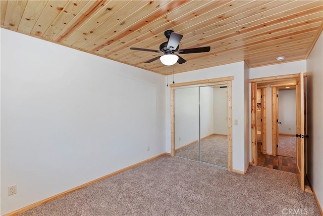 unfurnished bedroom with carpet flooring, a closet, ceiling fan, and wooden ceiling