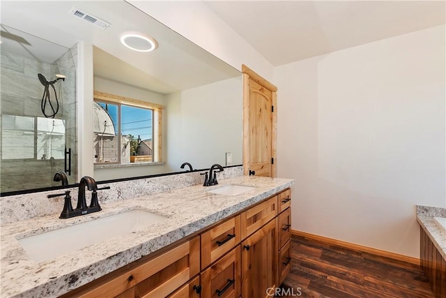 bathroom featuring hardwood / wood-style floors, vanity, and a shower with door