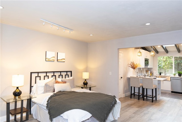 bedroom with beamed ceiling and light wood-type flooring