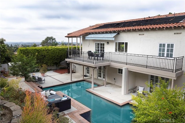 rear view of house with french doors, an outdoor hangout area, a fenced in pool, and a patio area